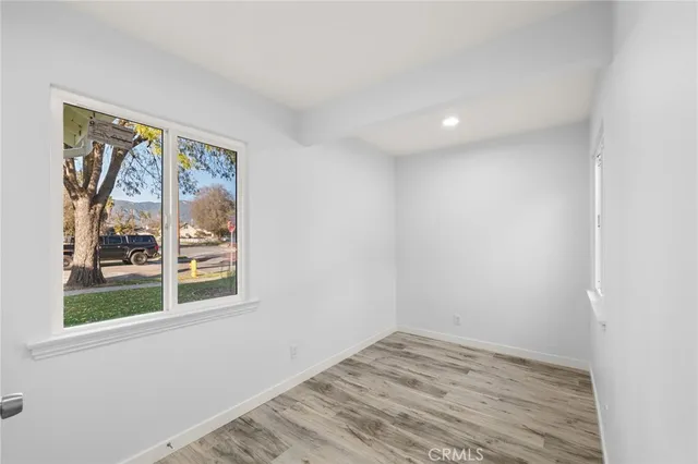 a view of empty room with window and wooden floor