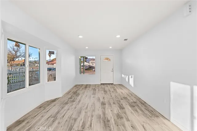 a view of a big room with wooden floor and windows