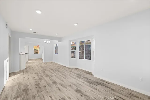 a view of empty room with wooden floor and windows