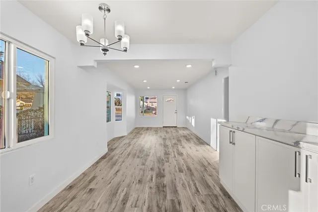 a view of a hallway with wooden floor and chandelier
