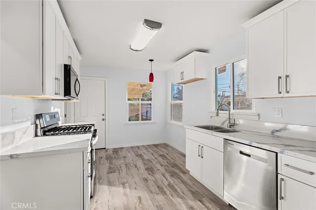 a kitchen with stainless steel appliances a sink stove and cabinets