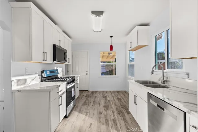 a kitchen with granite countertop a sink appliances cabinets and a counter space