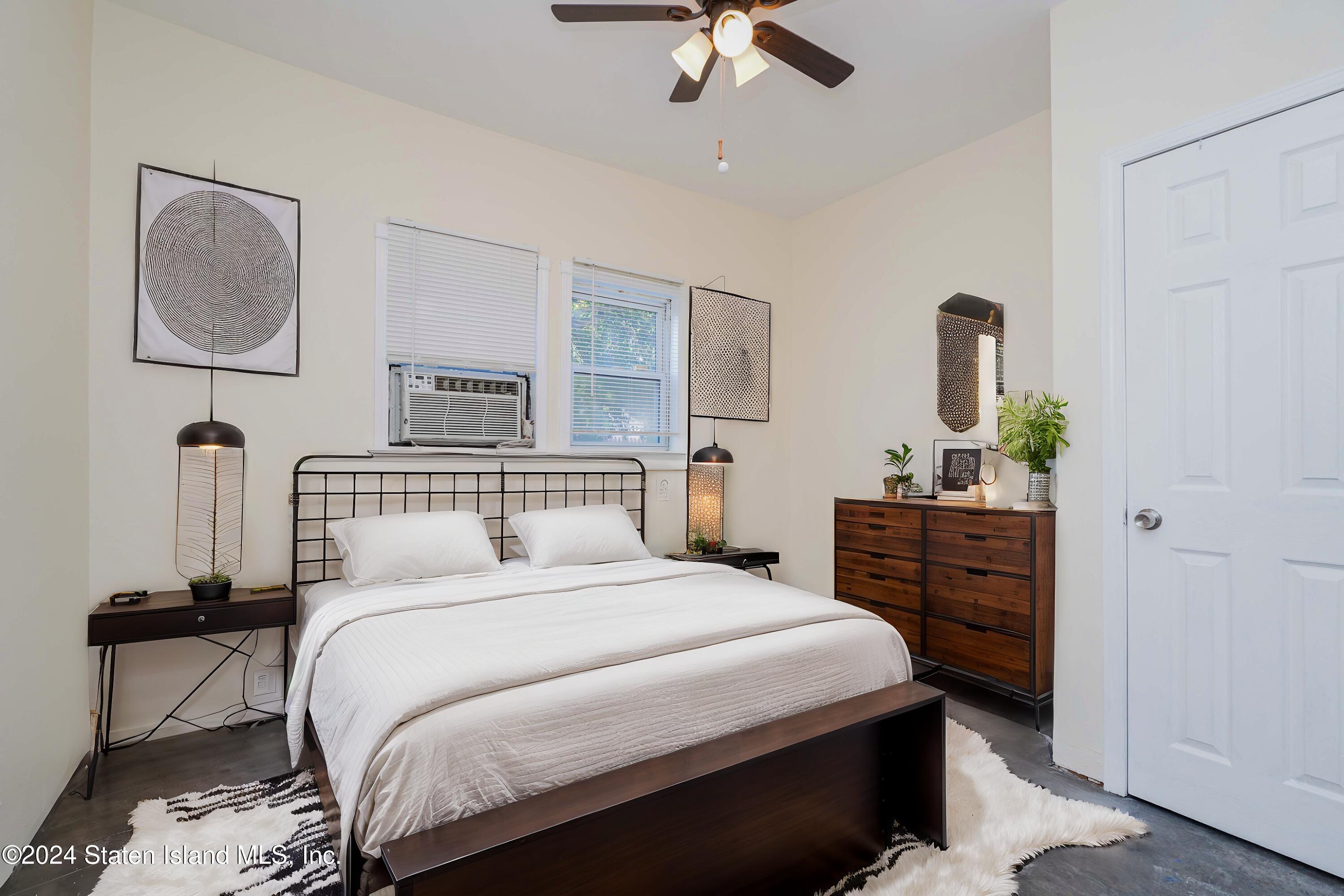 74 Fingerboard Road Staten Island, NY 10305 - Photo 14 of 18 a bedroom with a bed a mirror on dresser and a chandelier