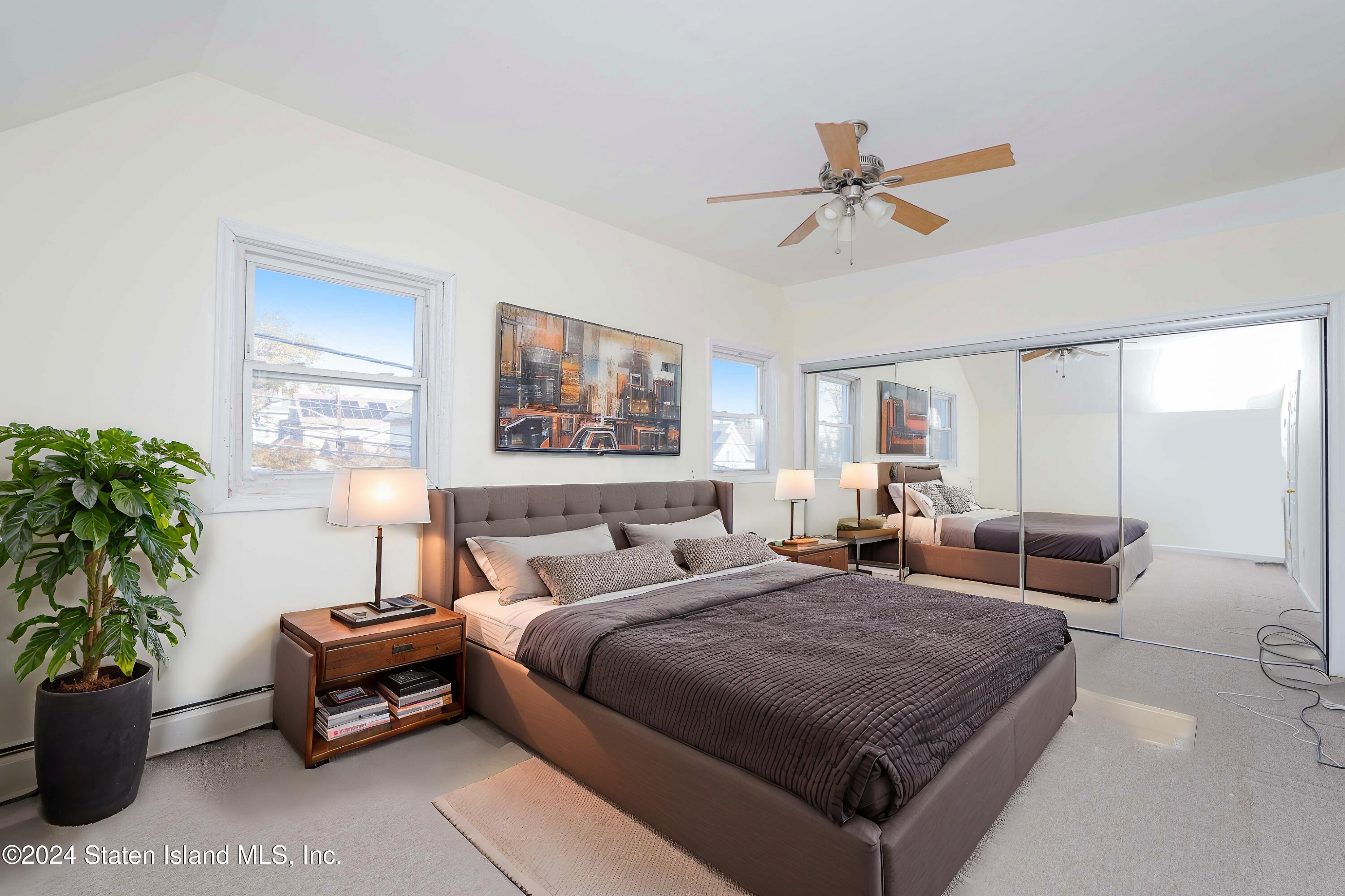 74 Fingerboard Road Staten Island, NY 10305 - Photo 15 of 18 a bedroom with a large bed and a chandelier