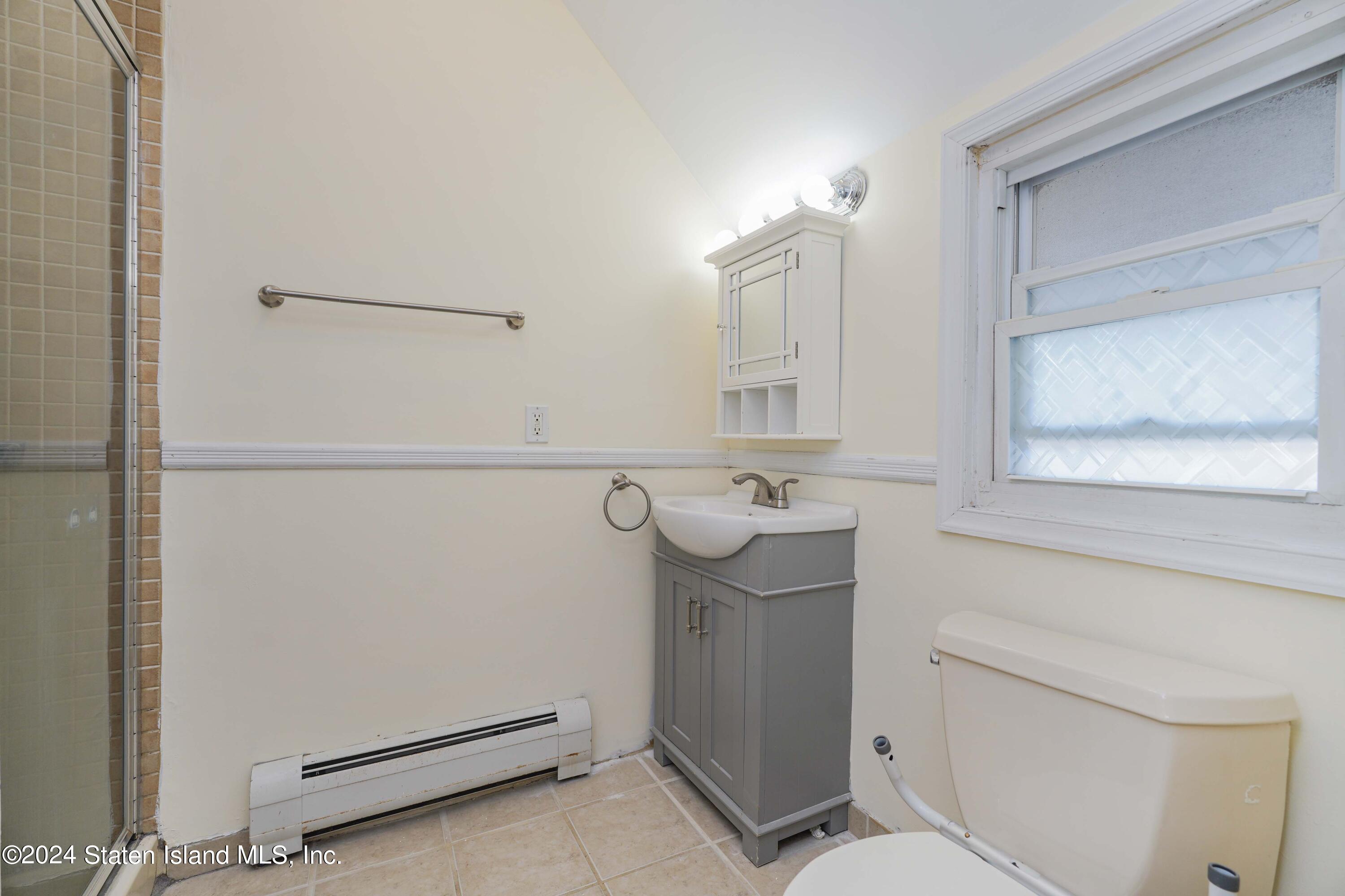 74 Fingerboard Road Staten Island, NY 10305 - Photo 17 of 18 a bathroom with a sink a toilet and a mirror
