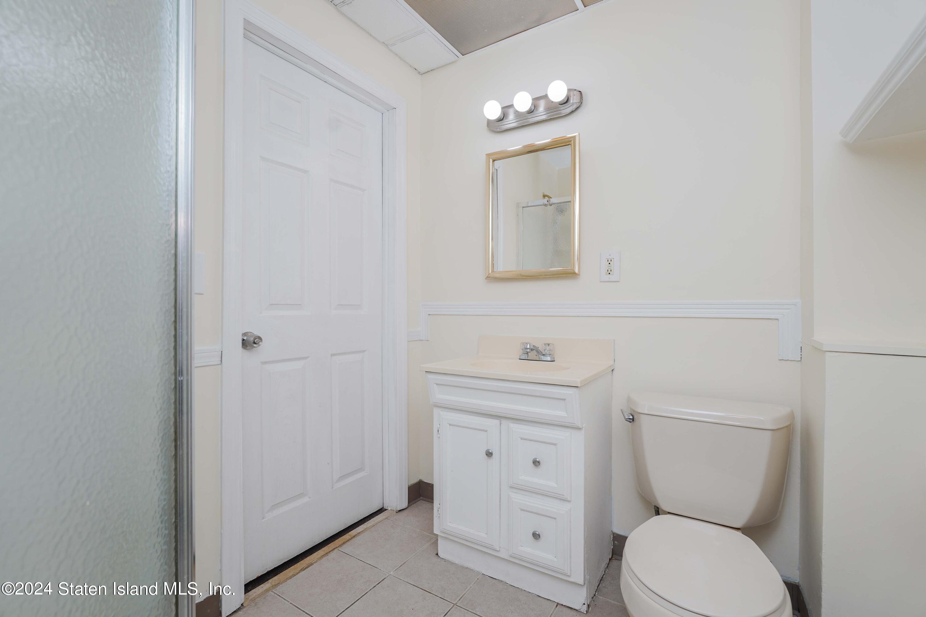74 Fingerboard Road Staten Island, NY 10305 - Photo 8 of 18 a bathroom with a toilet a sink and mirror