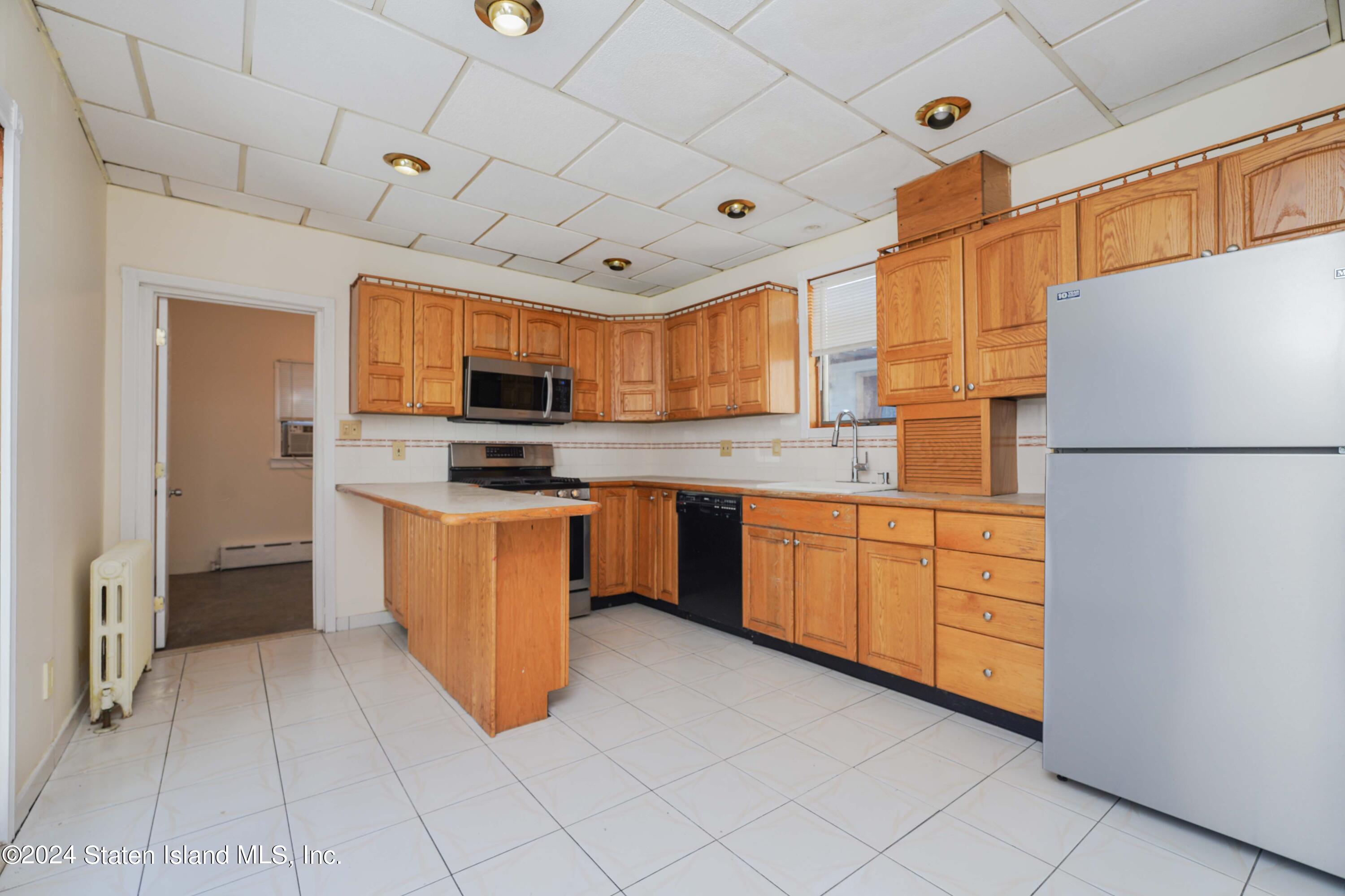 74 Fingerboard Road Staten Island, NY 10305 - Photo 9 of 18 a kitchen with stainless steel appliances granite countertop a refrigerator a stove top oven a sink and dishwasher