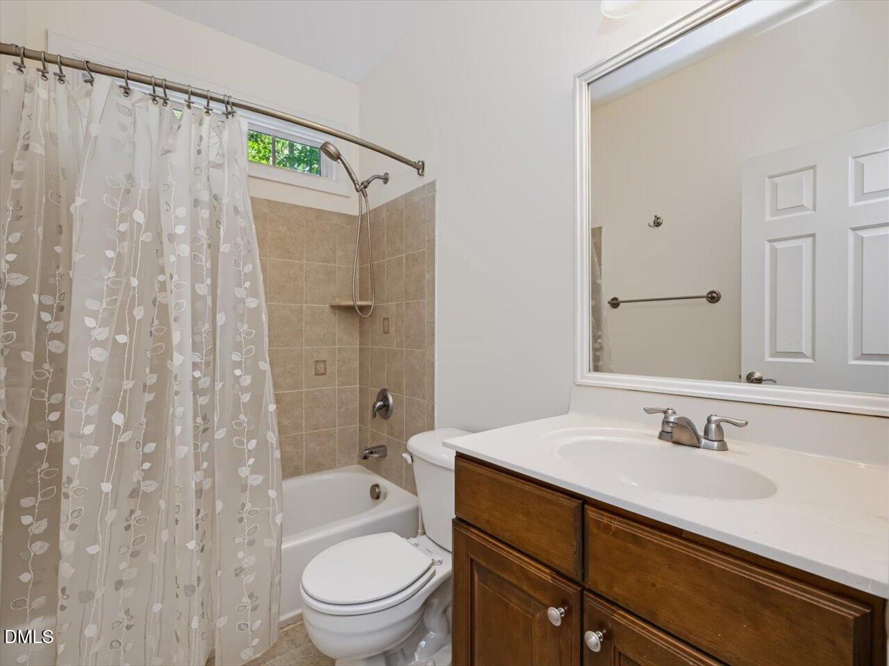 450 Ryan Road Pittsboro, NC 27312 - Photo 42 of 73 Hall Bath - Featuring Dark Wooded Cabinetry with White Countertops and Integrated Sink, Large Wall Mirror, and Tiled Shower-Tub Combination