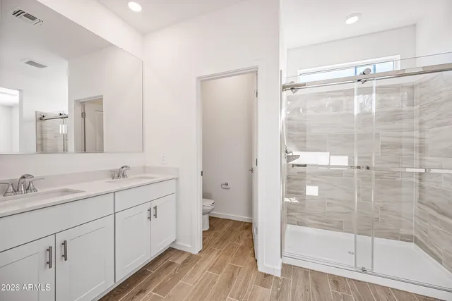 a bathroom with a double vanity sink mirror and shower