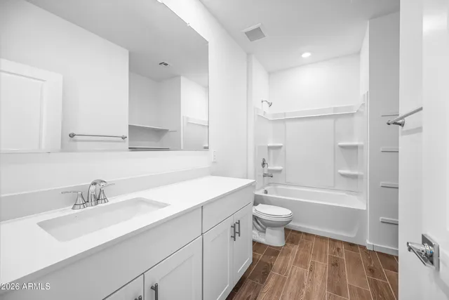 a bathroom with a sink a toilet a tub and a mirror