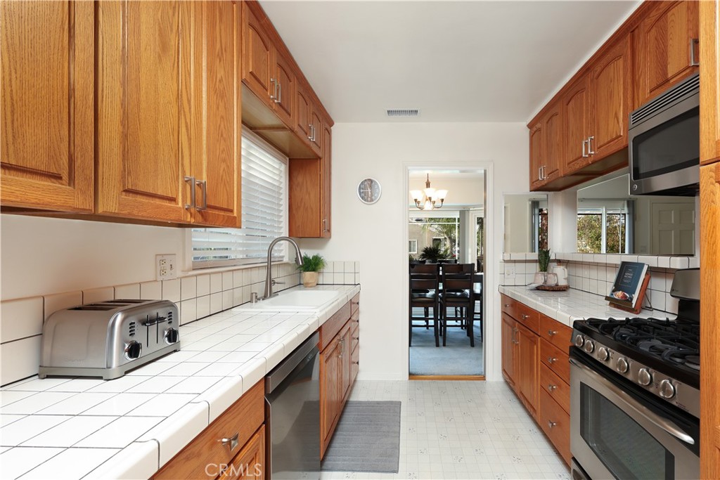 6116 Arbor Road Lakewood, CA 90713 - Photo 12 of 46 a kitchen with stainless steel appliances granite countertop a stove a sink and a refrigerator