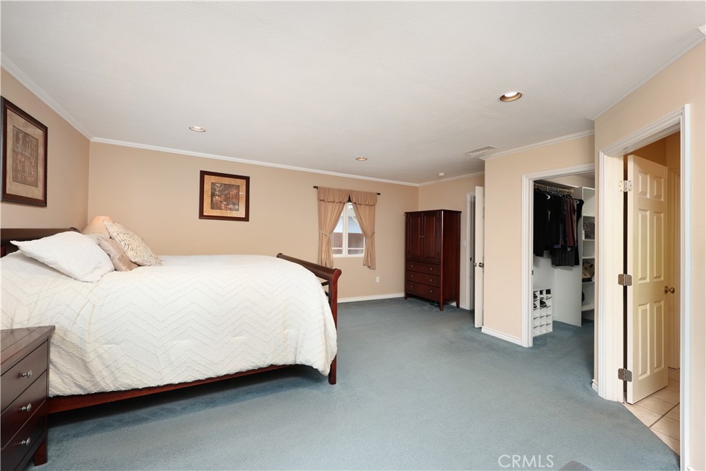 6116 Arbor Road Lakewood, CA 90713 - Photo 27 of 46 a spacious bedroom with a bed and walk in closet