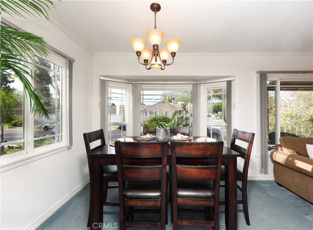 6116 Arbor Road Lakewood, CA 90713 - Photo 9 of 46 a dining room with wooden floor a chandelier a wooden table and chairs