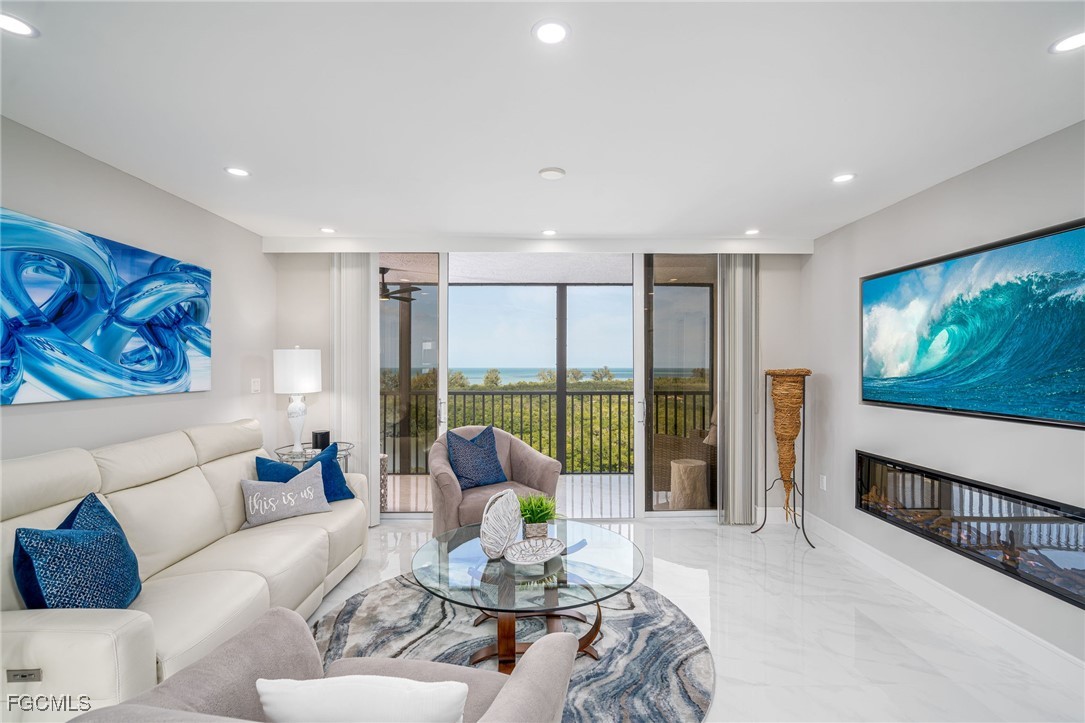 17 Bluebill Avenue, Unit 903 Naples, FL 34108 - Photo 6 of 33 a living room with furniture large window and a flat screen tv