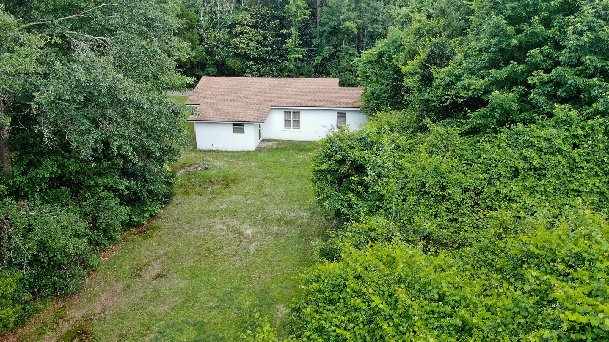 42 John Adams Street Freeport, FL 32439 - Photo 9 of 24 an aerial view of a house with yard and trees all around