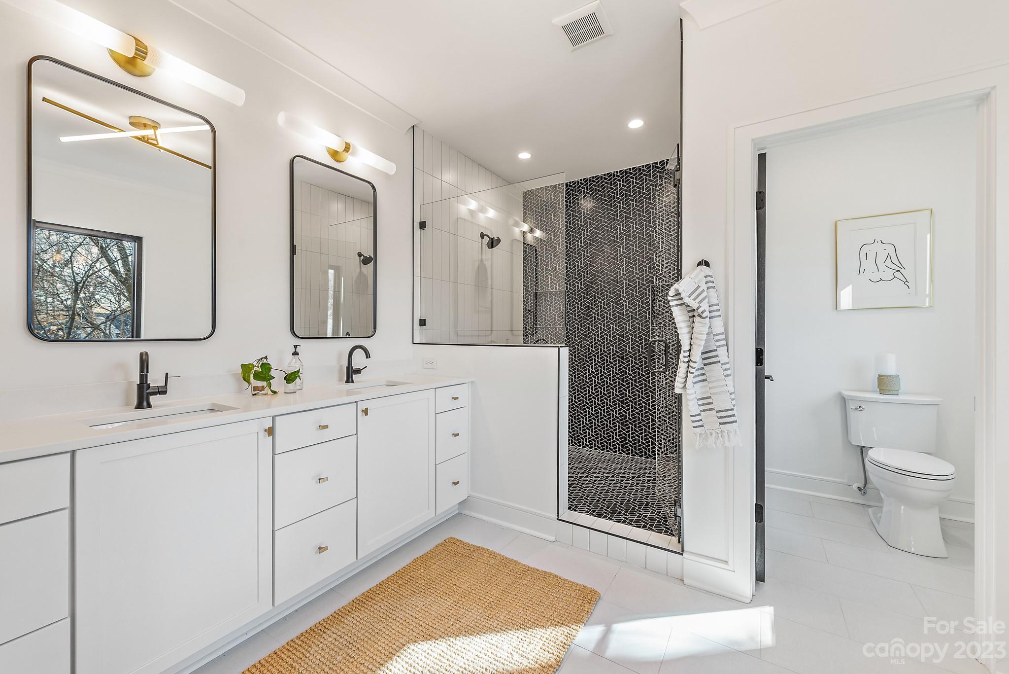 4338 Castleton Road Charlotte, NC 28211 - Photo 18 of 38 a spacious bathroom with a double vanity sink toilet mirror and shower