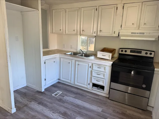 a kitchen with stainless steel appliances granite countertop a stove a microwave and a white cabinets