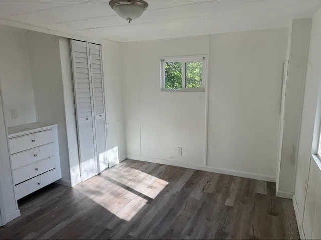 an empty room with windows and closet