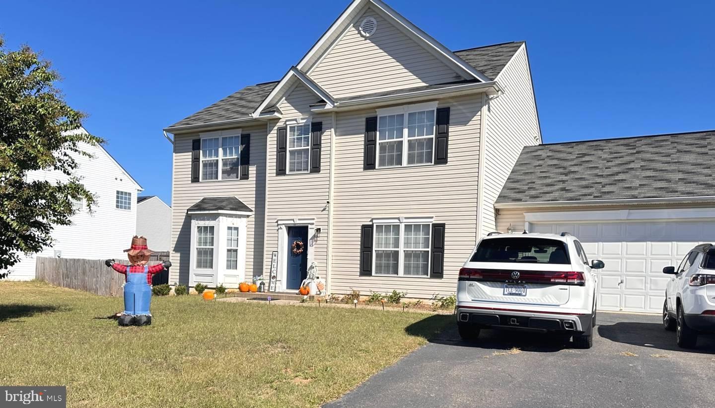 a front view of a house with a garden and parking space