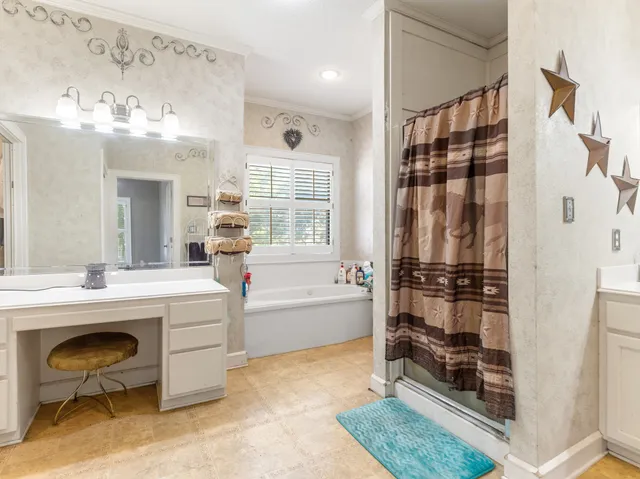 a spacious bathroom with a tub sink shower and a mirror