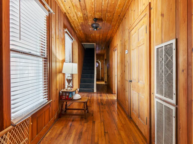 a view of outdoor space with a large window and wooden floor