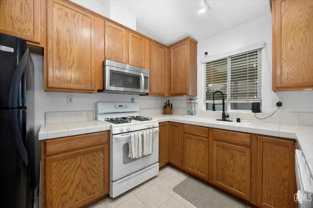 a kitchen with stainless steel appliances granite countertop a stove sink microwave and refrigerator