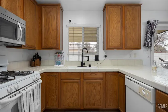 a kitchen with stainless steel appliances granite countertop a sink stove and microwave