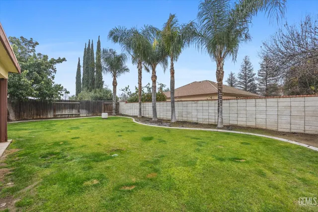 a view of a backyard with a garden and palm trees
