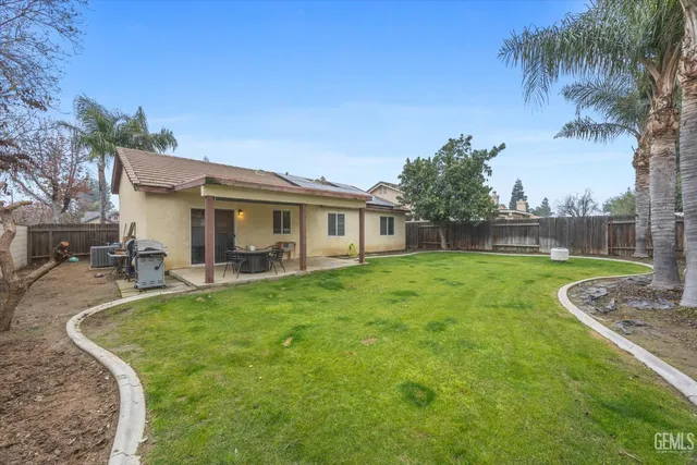 a view of a house with backyard and sitting area