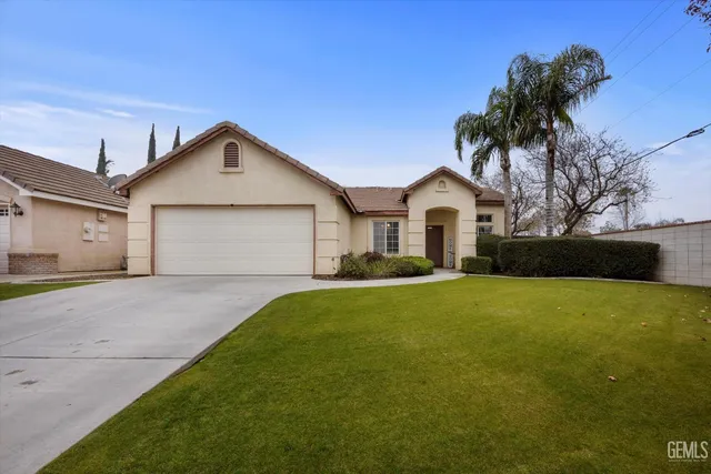 a front view of a house with a garden and yard