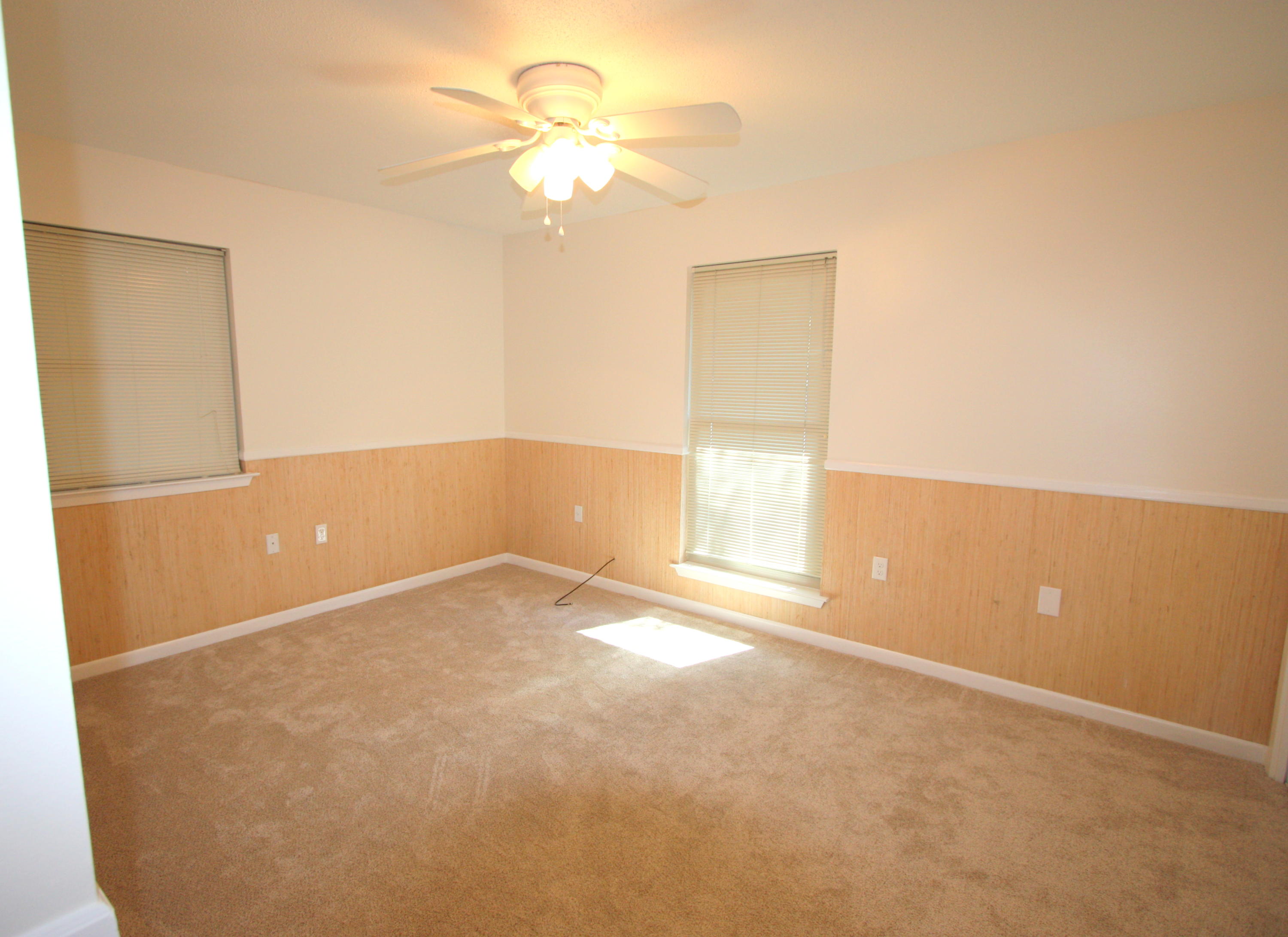 75 Country Club Road Shalimar, FL 32579 - Photo 11 of 24 an empty room with a chandelier fan and windows