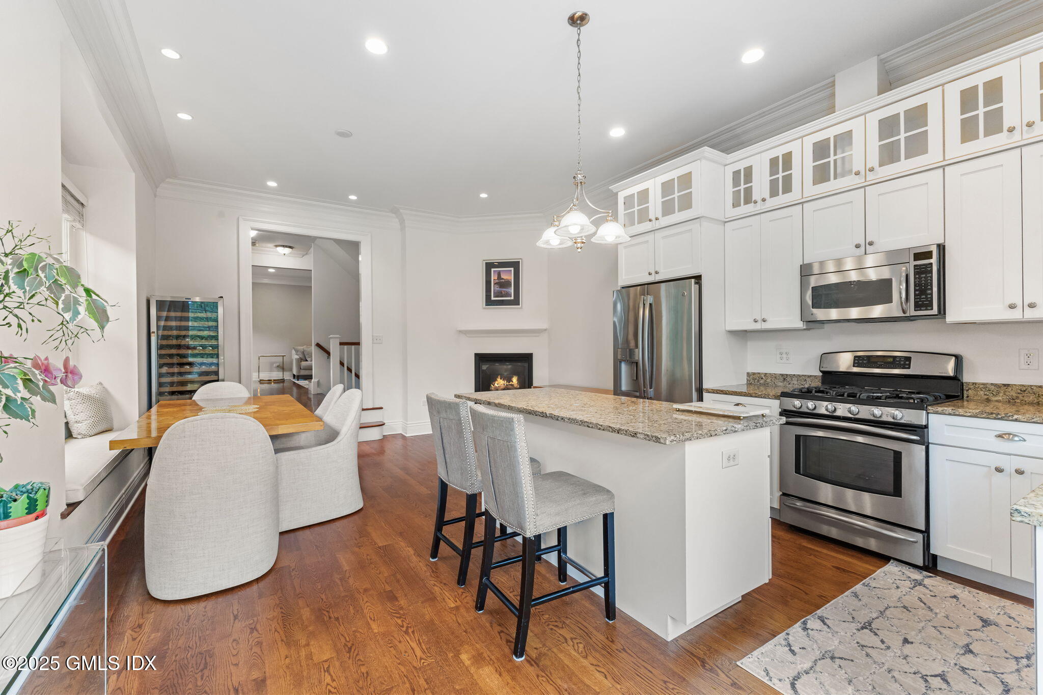 26 Church Street, Unit B Greenwich, CT 06830 - Photo 6 of 30 a kitchen with stainless steel appliances kitchen island granite countertop a stove a sink a refrigerator and a dining table with wooden floor