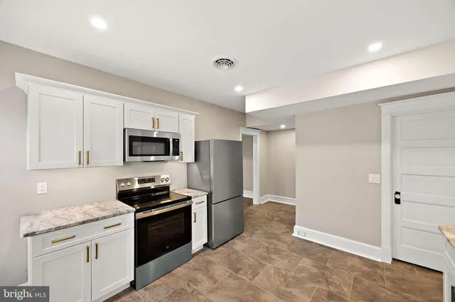 a kitchen with stainless steel appliances granite countertop a refrigerator and a stove top oven