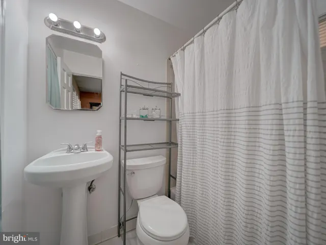 a bathroom with a toilet a sink and mirror