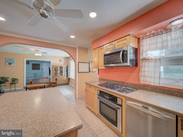 a kitchen with stainless steel appliances granite countertop a stove and a microwave with cabinets