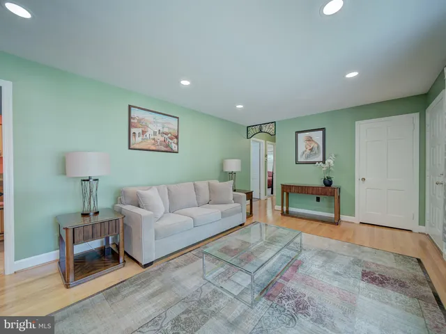 a living room with furniture and a painting on the wall