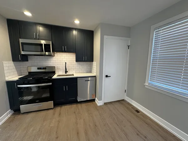 a kitchen with stainless steel appliances kitchen island granite countertop a stove a sink and a microwave