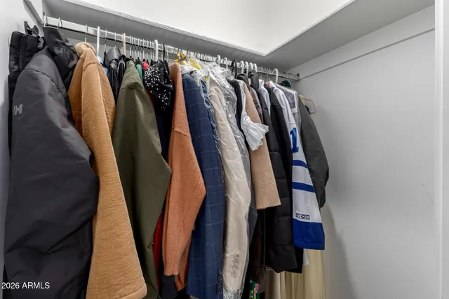 a view of walk in closet with clothes and shoes