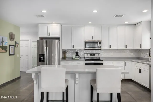 a kitchen with white cabinets and stainless steel appliances