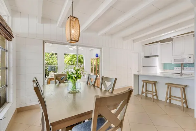a dining room with furniture potted plants and wooden floor