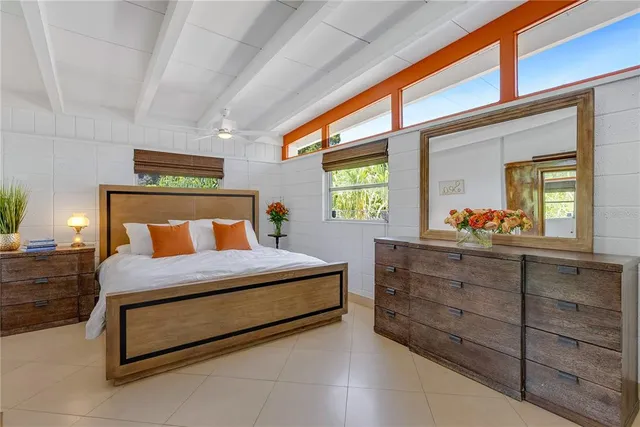 a bedroom with a bed and a dresser next to a window