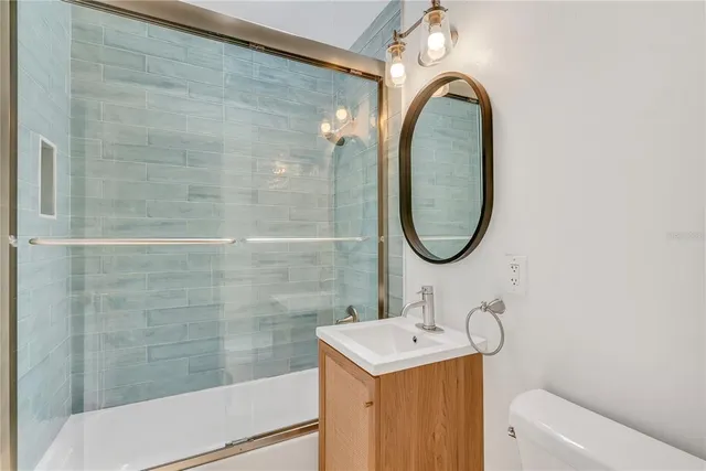 a bathroom with a sink a toilet and a mirror