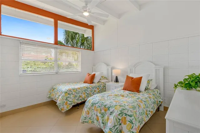 a bedroom with two beds and a potted plant