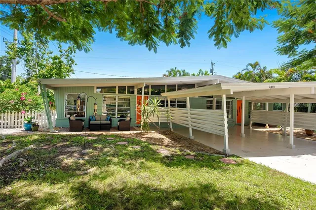 a view of a house with backyard porch and sitting area