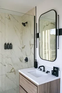 a bathroom with a sink vanity mirror and shower