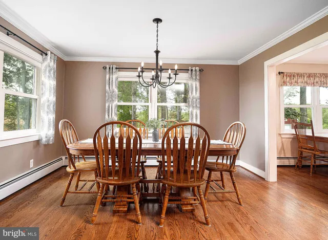 a kitchen with stainless steel appliances kitchen island granite countertop a stove a sink a refrigerator and white cabinets with wooden floor