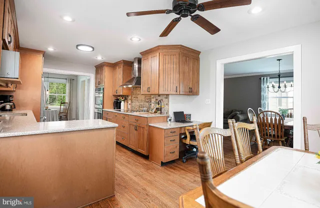 a kitchen with stainless steel appliances a refrigerator sink and wooden floor