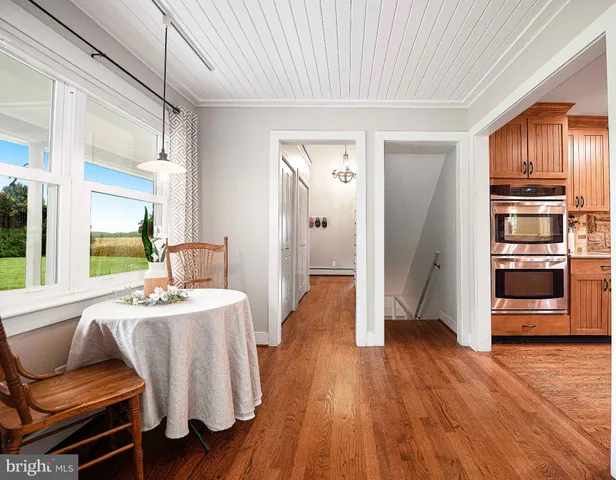 a dining room with wooden floor and furniture