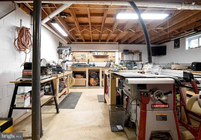 a roof deck with table and chairs and potted plants