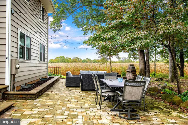 a view of a backyard with table and chairs and a large tree